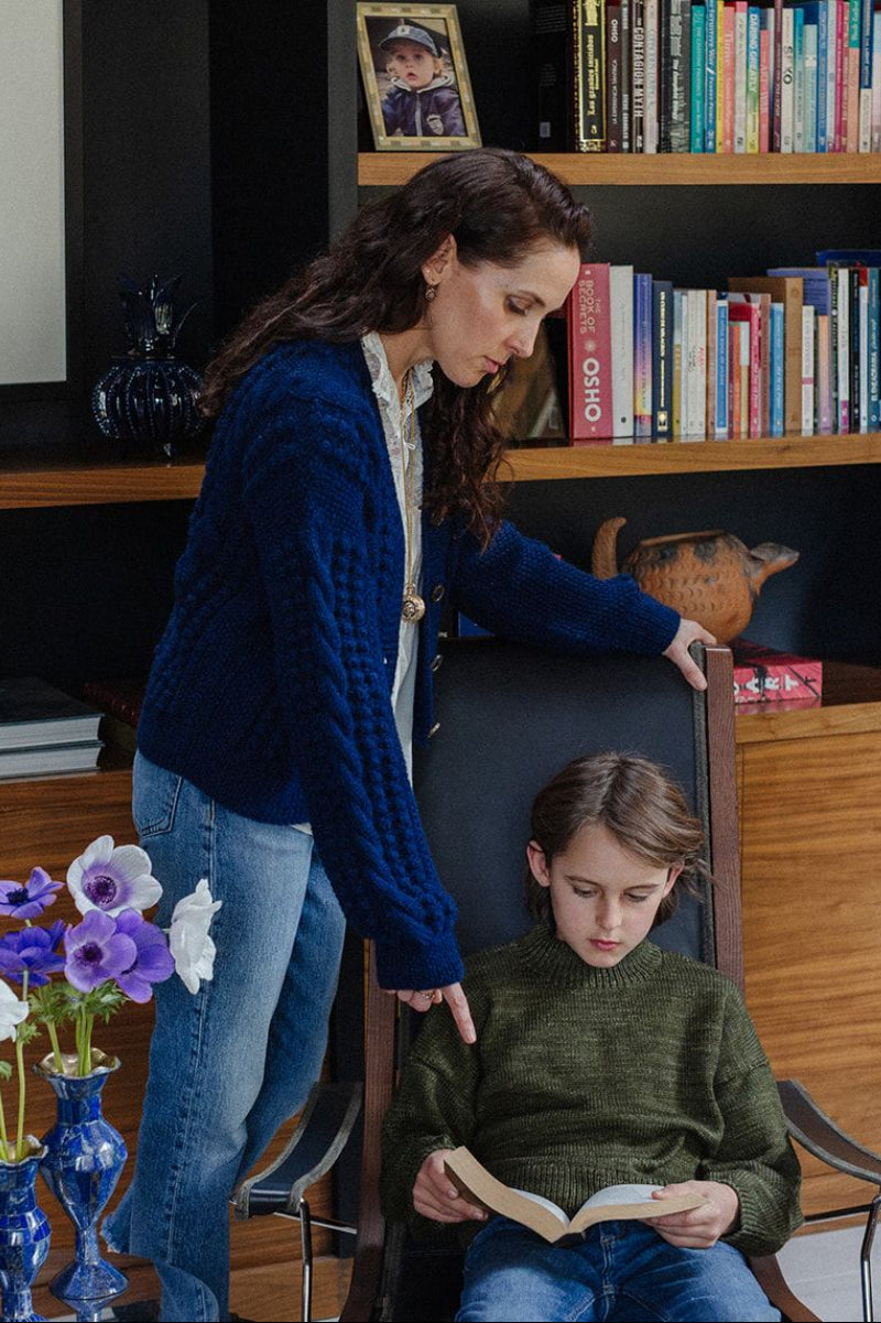 Woman and child in a home setting with books and decor
