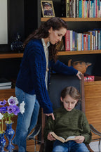 Woman and child in a home setting with books and decor